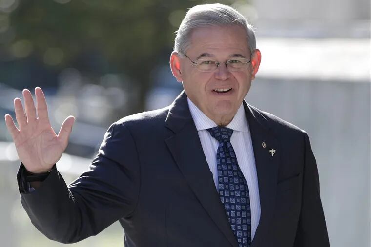 Sen. Bob Menendez waves to reporters while arriving at the Martin Luther King, Jr. Federal Courthouse.