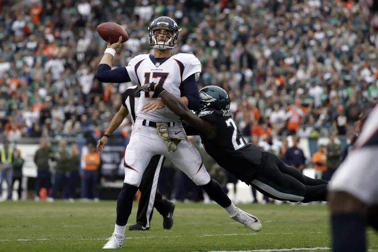 Not a fun day for Broncos quarterback Brock Osweiler, here hit by Eagles safety Malcolm Jenkins. (AP Photo/Michael Perez).
