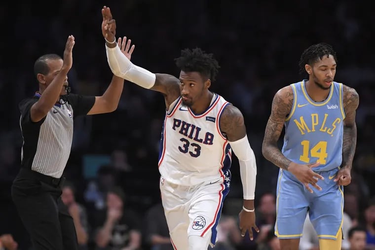 Sixers forward Robert Covington (center) gestures after hitting a 3-point shot as Los Angeles Lakers forward Brandon Ingram stands behind on Wednesday.