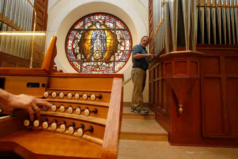 In the chapel at the Cathedral Basilica of SS. Peter and Paul, Adam Dieffenbach (left) plays a note so Colin Walsh can make pitch adjustments to the pipes of the organ Walsh's Collingdale company built and installed. &quot;The idea is to do something significant and long-lasting,&quot; he said of the project.