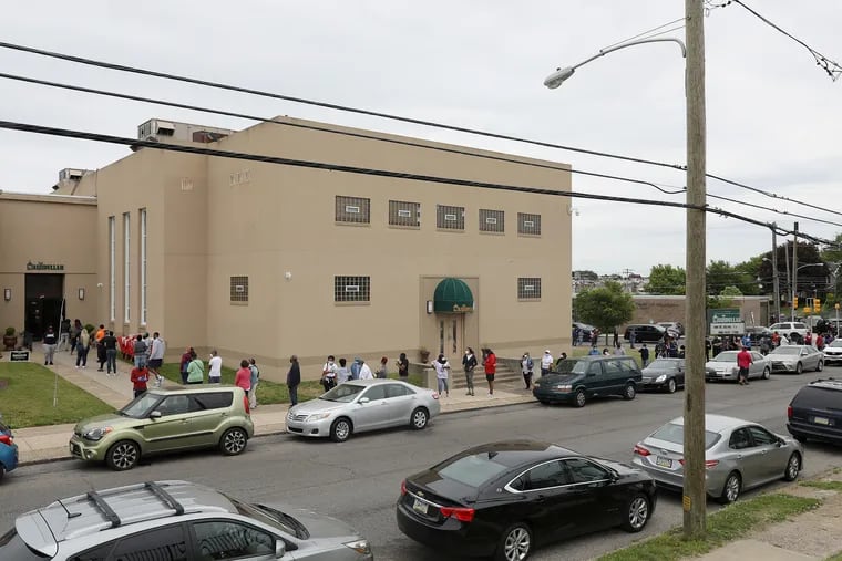 Dozens of voters line up outside Masjidullah in Philadelphia's East Mount Airy section on Pennsylvania's primary election day. There were fewer polling locations across the city due to the coronavirus pandemic.