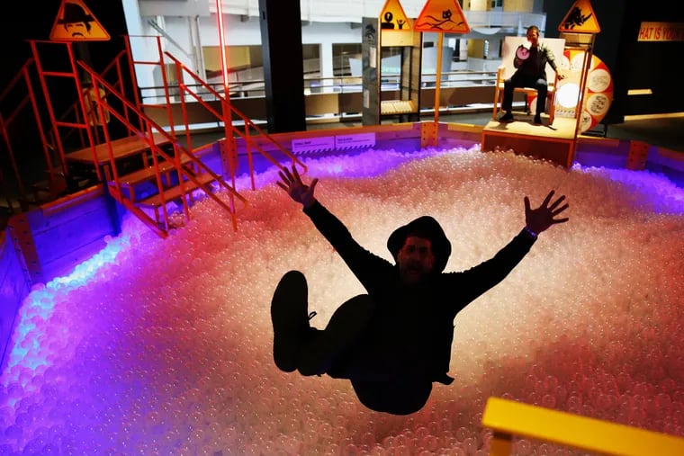 David Borgenicht demonstrates falling into a ball pit in the "Worst Case Scenario" exhibit at the Franklin Institute, based on the Quirk Books series.