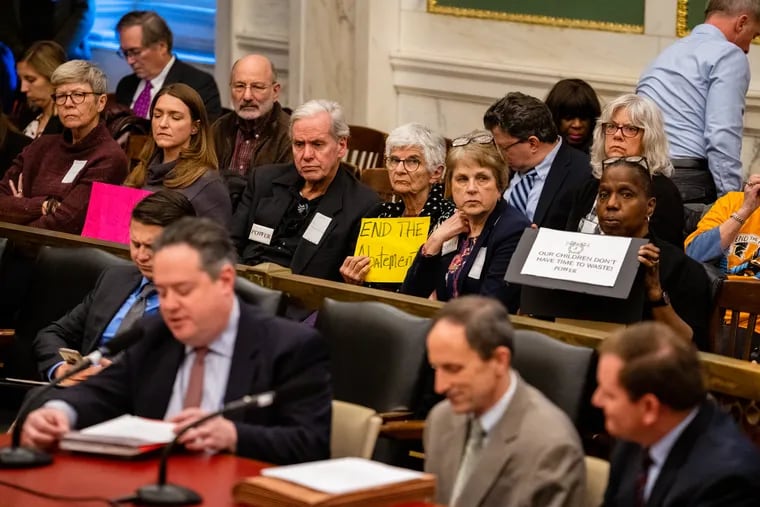 Members of the Philadelphia Neighborhoods Network hold signs in support of a bill to change the 10-year tax abatement at City Hall, Tuesday, Dec. 3, 2019.