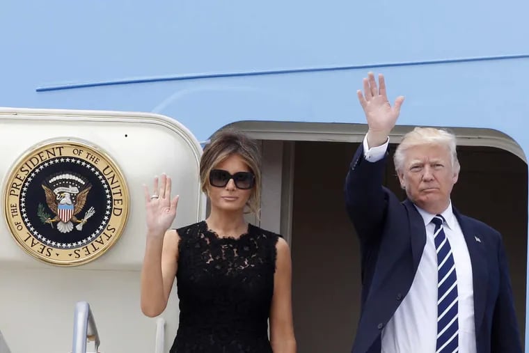 President Trump and first lady Melania Trump wave to reporters before boarding Air Force One to Brussels, at the end of a two-day visit to Italy.