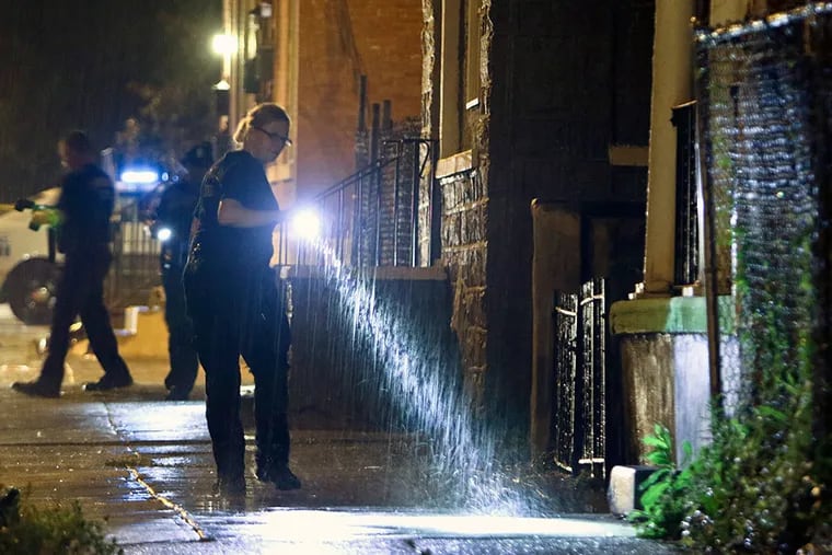 Police investigate the crime scene on Ogden Street near 41st Street in West Philadelphia, after 10 people, including three children, were wounded in a shooting at a cookout. JOSEPH KACZMAREK / For The Inquirer