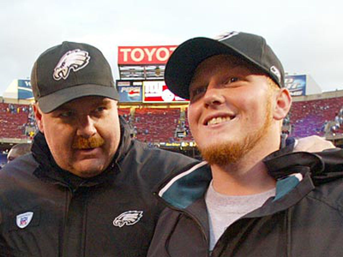 Reid walking off the field with his son Britt after the Eagles beat the Giants in 2004. 