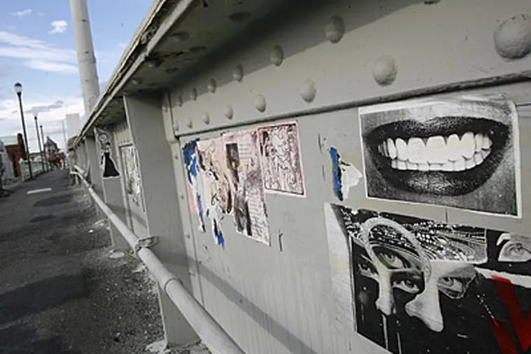 The South Street Bridge is closing Monday to be torn down and replaced. Meanwhile, graffiti and other artists have been using the bridge as a canvas. A poster of a smile and other images are plastered on the bridge. (Charles Fox / Staff Photographer )