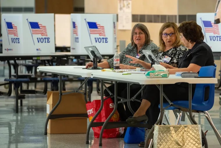 Poll workers await voters Tuesday at Bensalem High School.