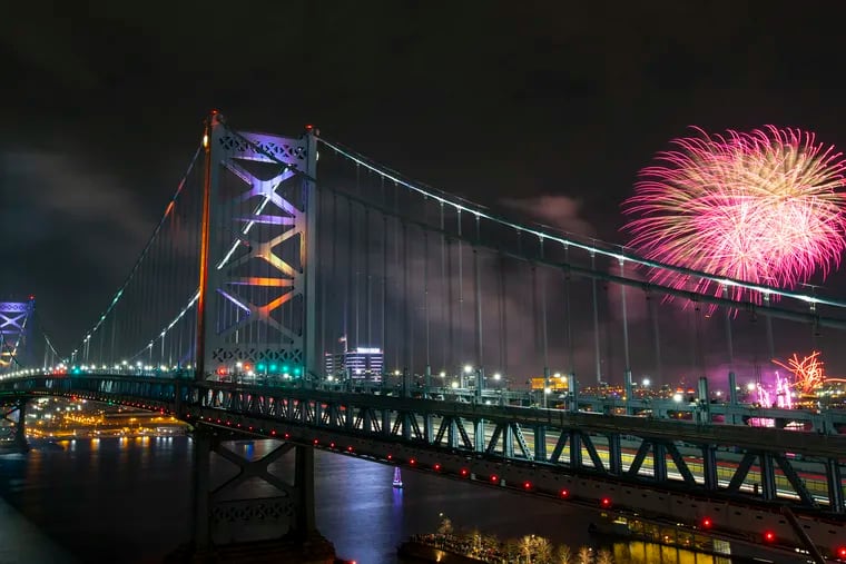 Fireworks over the Delaware River are viewed from the rooftop deck at the One Water Street apartment building in Philadelphia and framed by the Benjamin Franklin Bridge on New Year's Eve.