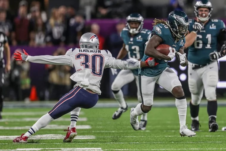 Eagle running back Jay Ajayi runs through the tackle of New England’s Duron Harmpn in the second quarter.