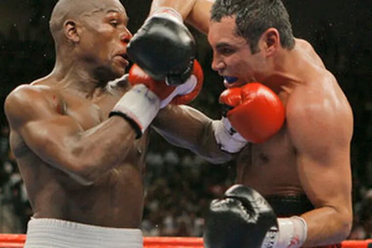 Floyd Mayweather Jr. (left) and Oscar De La Hoya trade inside punches in the 10th round of Saturday&#0039;s junior-middleweight fight.
