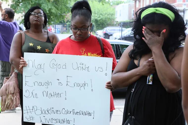 Praying at a Black Lives Matter rally in Camden are (from left) Naomi Phillips, Taishai Ward, and Female Figueroa. Some local African American protest leaders said the killings in Dallas won’t curtail their demands for justice at the hands of law enforcement.