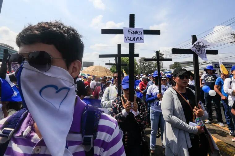 Anti-government protesters join a Stations of the Cross procession on Good Friday, carrying signs demanding the release of political prisoners in Managua, Nicaragua, Friday, April 19, 2019. Good Friday religious processions in Nicaragua’s capital have taken a decidedly political tone as people have seized on a rare opportunity to renew protests against the government of President Daniel Ortega. (AP Photo/Alfredo Zuniga)