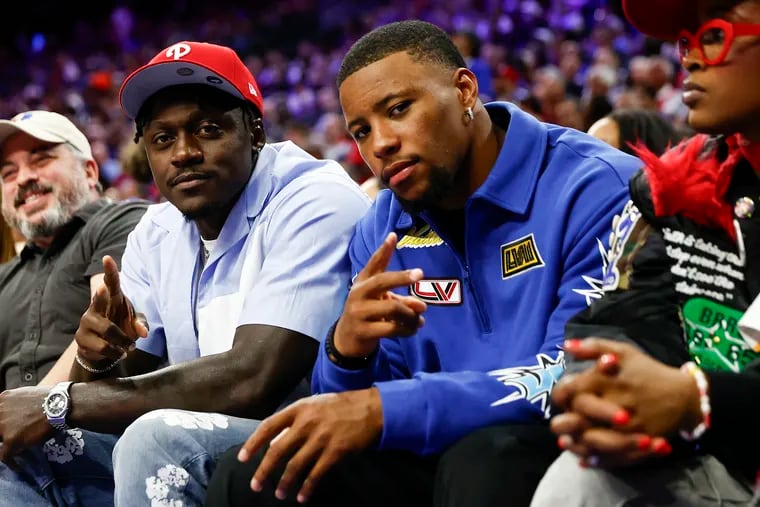 Eagles wide receiver A.J. Brown (left) and running back Saquon Barkley attending the Sixers' Game 6 against the Knicks on May 2.