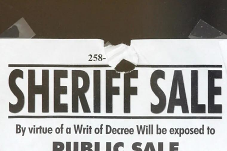 A sheriff sale notice is taped to the window of American Loft between 2nd and 3rd on Brown Street. ( David Swanson / Staff Photographer )