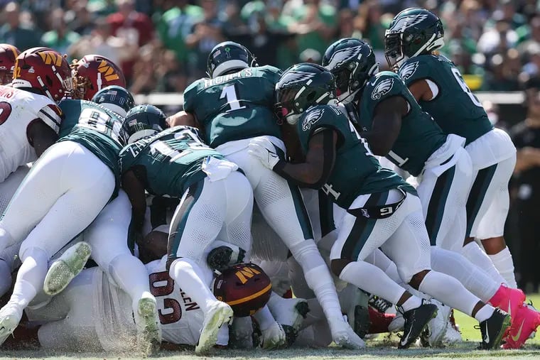 Eagles quarterback Jalen Hurts attempts a second-quarter quarterback sneak against the Commanders on Sunday.  The Eagles were called for an offsides penalty on the play.