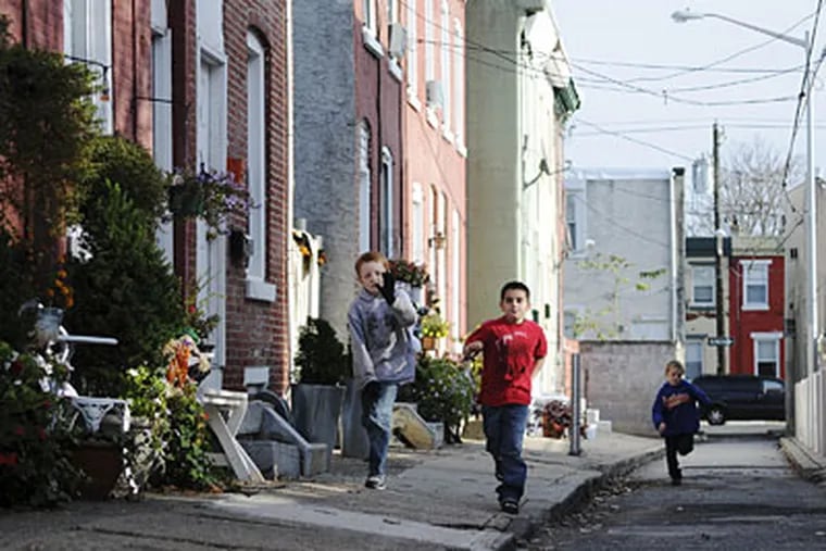 Michael Locke, 9, Timmothy Chase, 7, and Kyle Locke, 7 run down Gordon Street, which they helped clean.  (Kriston J. Bethel / Staff Photographer)