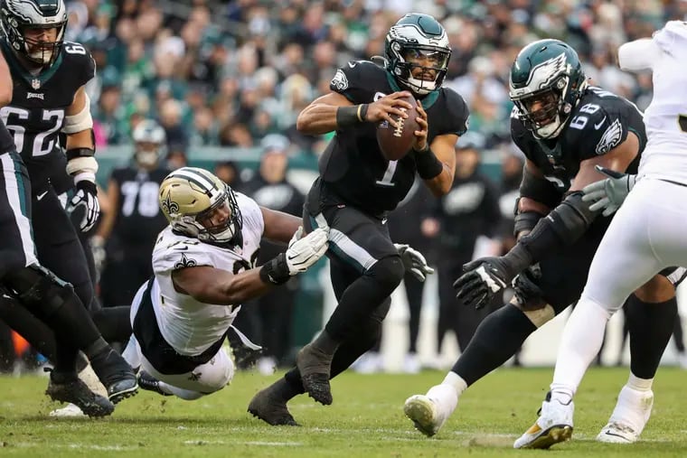 Eagles quarterback Jalen Hurts (1) escapes from Saints defensive tackle Shy Tuttle (99) during the third quarter Sunday.