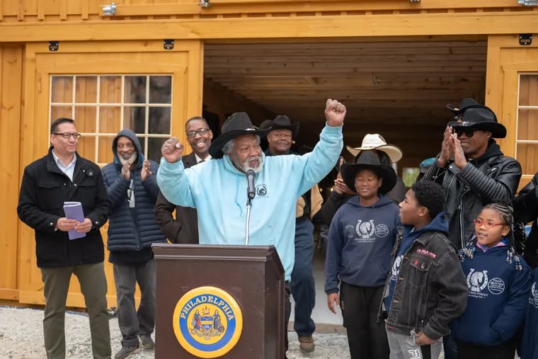 Ellis "El-Dog" Ferrell Jr. celebrates the opening of Fletcher Street Urban Riding Club's new stable in East Fairmount Park with Parks & Recreation Commissioner Orlando Rendon (left) and City Council President Darrell L. Clarke (behind Ferrell) along with friends and family.