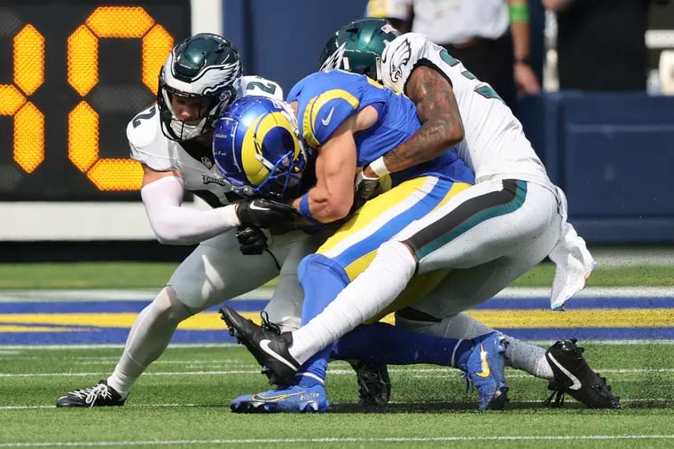Eagles safety Reed Blankenship (left) and cornerback Eli Ricks stop Cooper Kupp. The Rams wide receiver had a big start to the game, but the Eagles secondary reversed things in the second half.