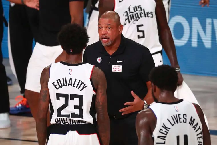 Sixers coach Doc Rivers talks with guard Lou Williams (23) during the NBA restart while the coach of the Los Angeles Clippers.