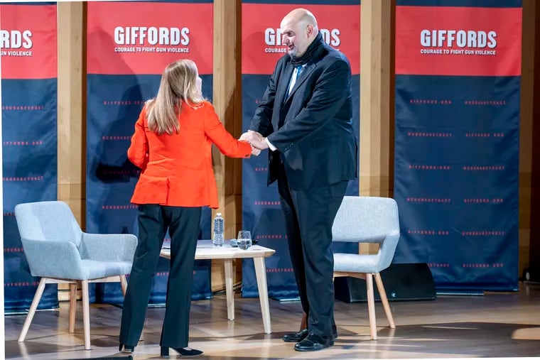 Pennsylvania Lt. Gov. John Fetterman, the Democratic Senate front-runner, greets moderator Debbie Mucarsel-Powell as he arrives on stage for a gun-violence prevention forum on Monday at the National Constitution Center.