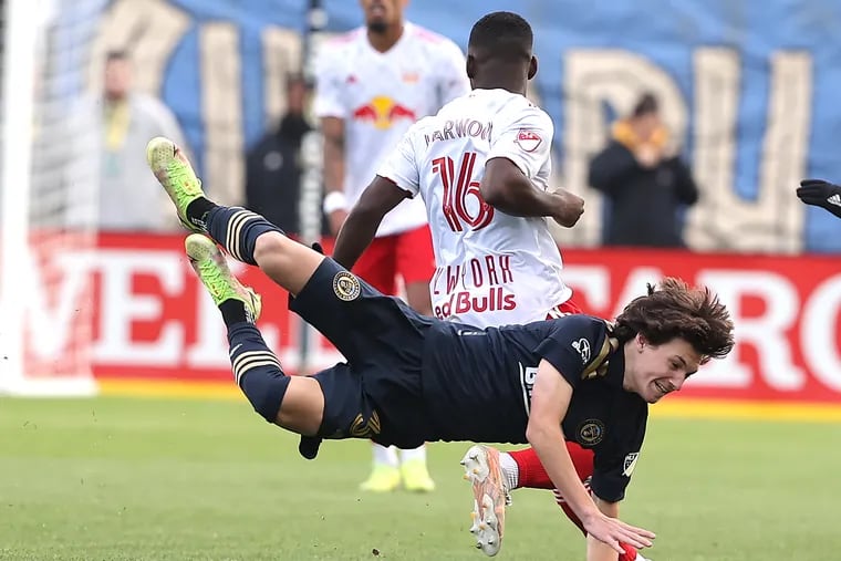 Paxten Aaronson, bottom, of the Philadelphia Union is leveled by Dru Yearwood of the New York Red Bulls during their playoff game on Nov. 20, 2021  at Subaru Stadium in Chester, PA.