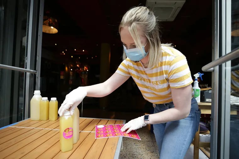 Krista Micheletti puts a label on to-go margaritas at El Vez restaurant on 13th Street in Philadelphia, Pa. on May 21, 2020. The restaurant named a margarita after Governor Tom Wolf. Gov. Wolf signed a bill that temporarily allows Pennsylvania restaurants and bars to sell cocktails to-go.