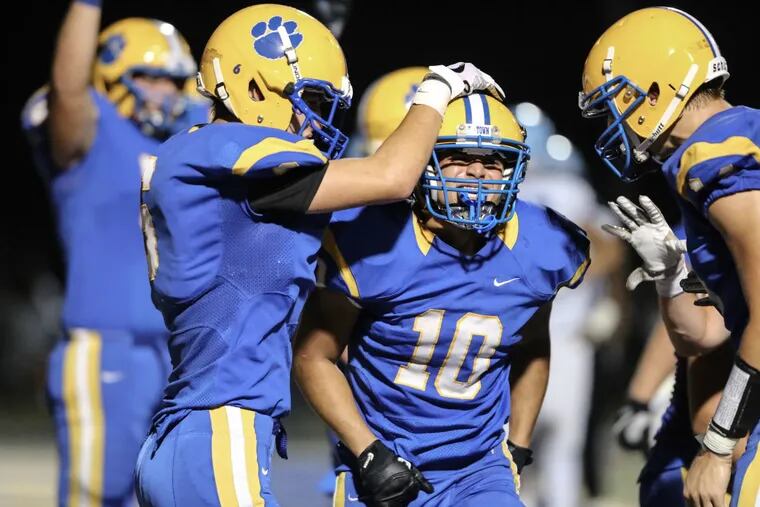 Downingtown East’s Garvey Jonassaint (10) celebrates with his teammates after scoring a touchdown against North Penn during the fourth quarter in Downingtown on Friday.
