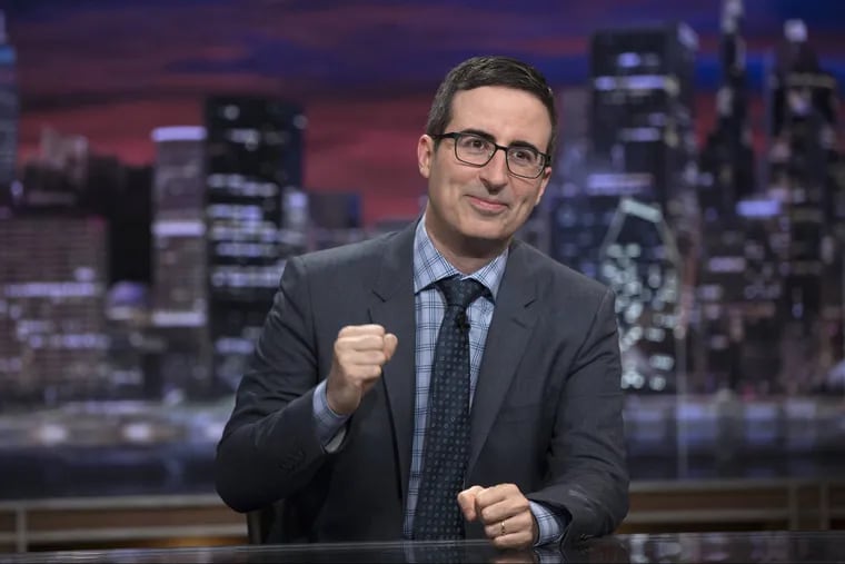 This image released by HBO shows John Oliver on the set of "Last Week Tonight with John Oliver." With the return of Oliver to HBO and Alec Baldwin's guest hosting slot on "Saturday Night Live," this is shaping up like a big weekend for late-night's treatment of the new president.