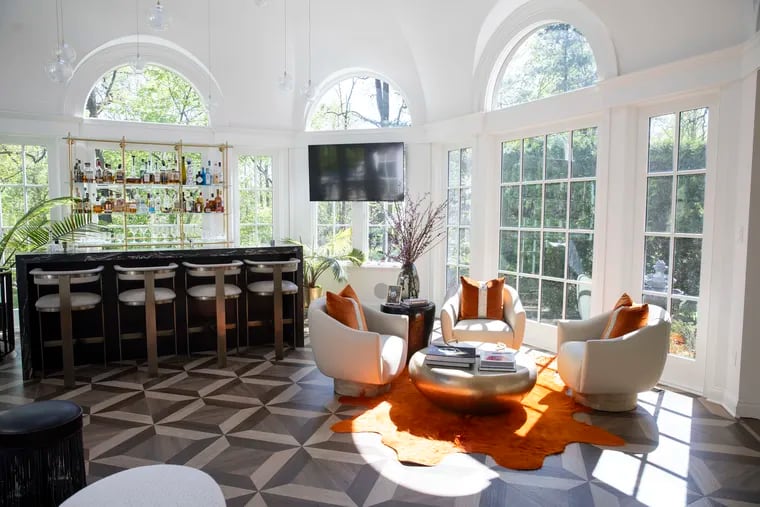 Several cozy seating areas and a bi-level bar make the solarium in this Bryn Mawr home the "hang out spot" for the owners' six children, who are all young adults.