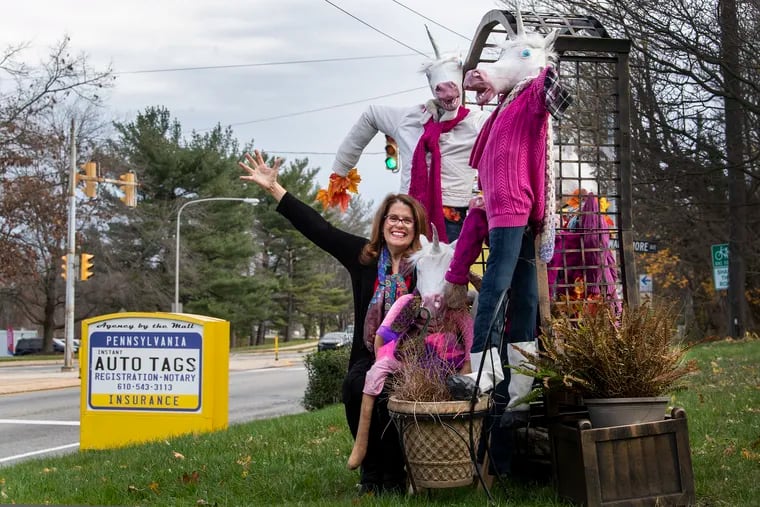 Susan Triggiani is pictured with her magical unicorn display on the front lawn of her business, Agency by the Mall, in Springfield, Delaware County.