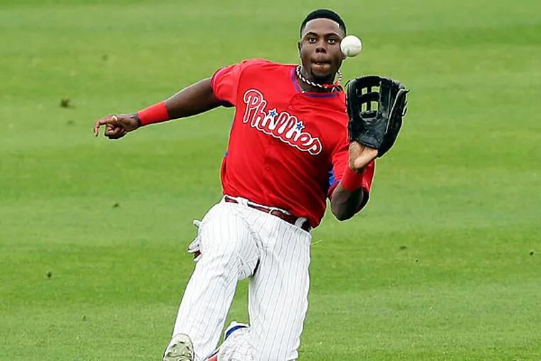 Philadelphia Phillies center fielder John Mayberry Jr. catches a fly
ball hit by New York Yankees' Brett Gardner during the fourth inning
of an exhibition baseball game Thursday, March 6, 2014, in Clearwater,
Fla. (AP Photo/Charlie Neibergall)