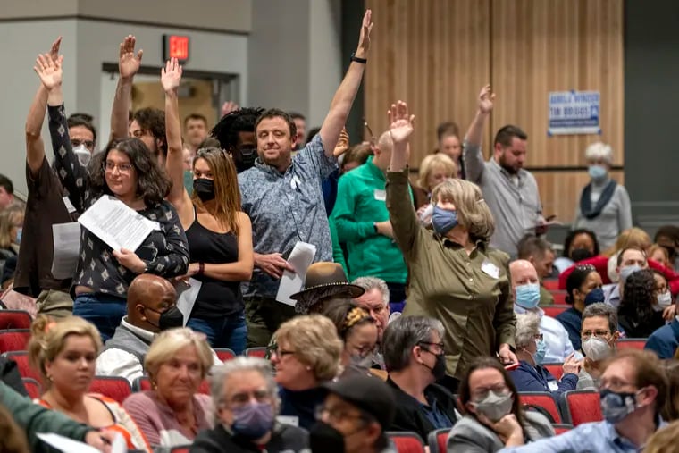 Members of the Montgomery County Democratic Committee stand to vote on a point of order as they hold their endorsement convention for local elections at Colonial Middle School in Plymouth Meeting on Thursday.