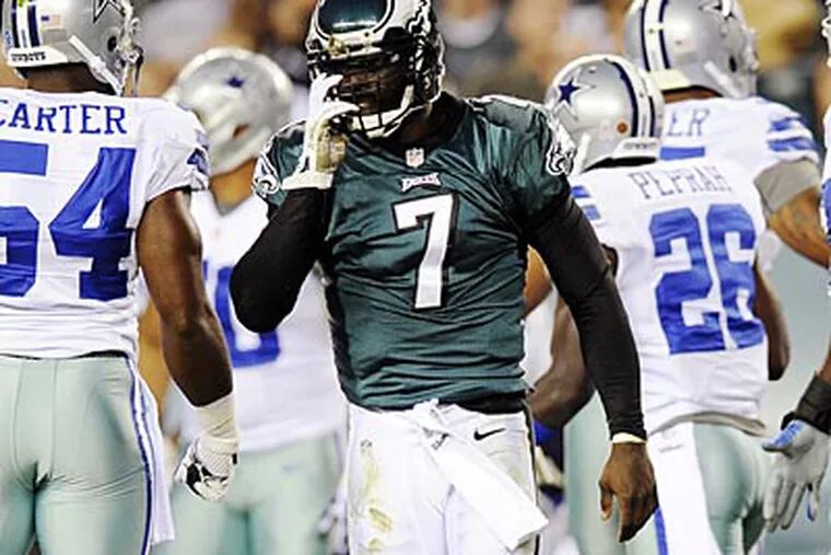 Eagles quarterback Michael Vick (7) adjusts his helmet
after being tackled in the first half of an NFL football game against
the Dallas Cowboys, Sunday, Nov. 11, 2012, in Philadelphia. (AP
Photo/Michael Perez)