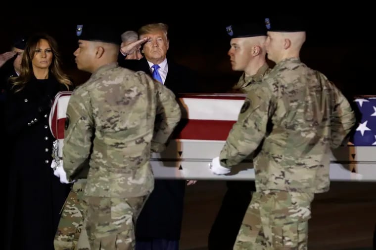 President Donald Trump and first lady Melania Trump watch as a U.S. Army carry team moves a transfer case containing the remains of Chief Warrant Officer 2 David C. Knadle, of Tarrant, Texas, on Thursday at Dover Air Force Base in Delaware.