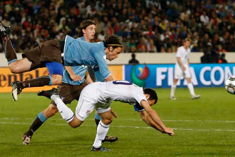 Landon Donovan (front) tumbles during the Confederations Cup match against Italy. Donovan had the only U.S. goal.