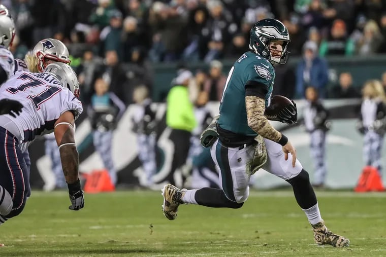 Eagles quarterback Carson Wentz runs out of the pocket in the third quarter to avoid being sacked and to tries to pick up a first down in last week's loss to the Patriots.