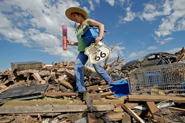 Susan Kates salvages items from the rubble of a friend's home in Moore, Okla. Cleanup continued two days after a huge tornado roared through the Oklahoma City suburb, flattening a wide swath of homes and businesses.