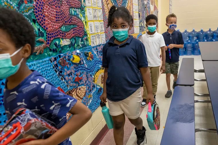 Khamoni Davis-Victor, 7, makes way to class after lunch period at Yorkship School in Camden in June. The district announced Wednesday that masks will be mandatory for two weeks when classes resume on Jan. 3 after the holiday recess.