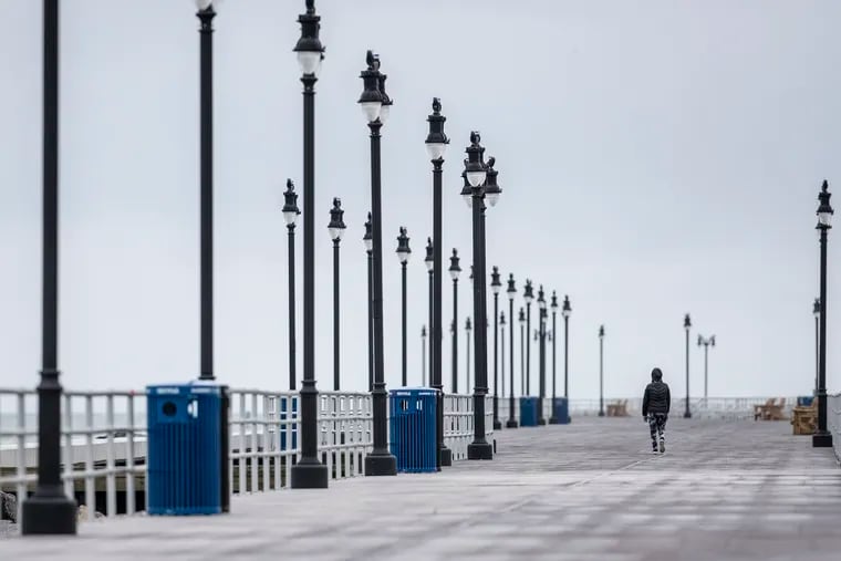 A solitary pedestrian walks along the the north end of Atlantic City near the Ocean Casino on Wednesday. The spread of the coronavirus has turned the Jersey Shore into one long ghost town.