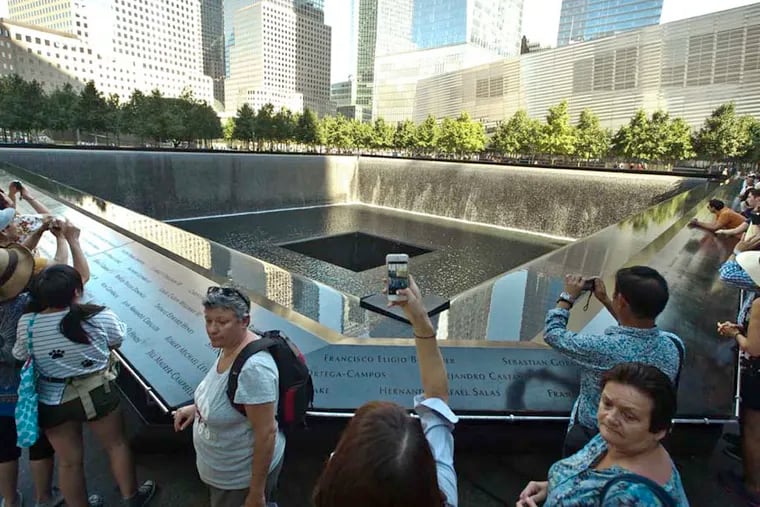 People gather around the south tower reflecting pool of the 911 Memorial in New York City.  ( RON TARVER / Staff Photographer ) September 4 2014