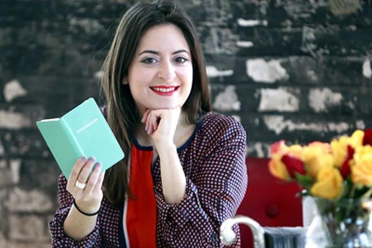 Nicole Paloux is holding a a little blue book from Tiffany & Co. posing for photo at her new office in North Philly. ( AKIRA SUWA  /  Staff Photographer )