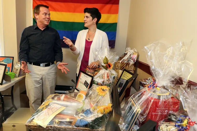 Bill Davidson, a former LGBT pride festival organizer, talks with Rachel Stevenson, president of LGBTea Dances, as they ready raffle items for the Chester County Pride festival in Phoenixville this weekend, the first since 2005.