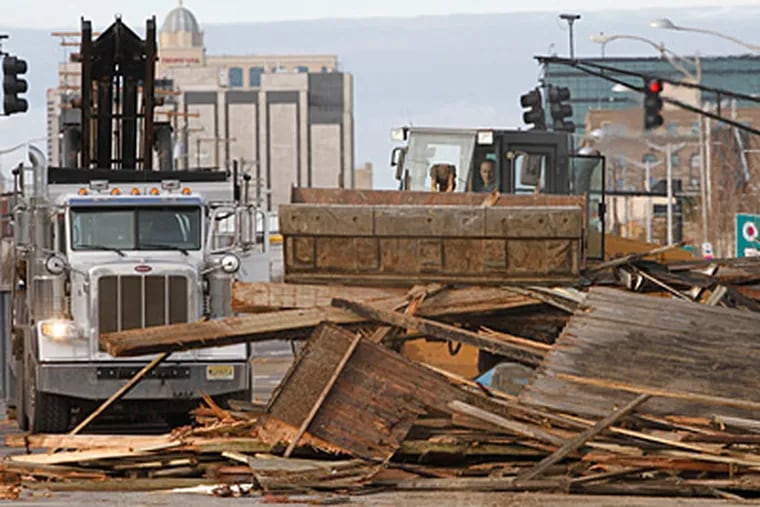 The Atlantic City public works department on Wednesday cleans up a section of boardwalk washed onto Atlantic Avenue. ( Michael S. Wirtz / Staff Photographer )