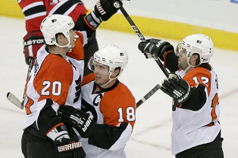 Chris Pronger (left) celebrates game's first goal with Mike Richards (center) and Simon Gagne. (Yong Kim / Staff Photographer)