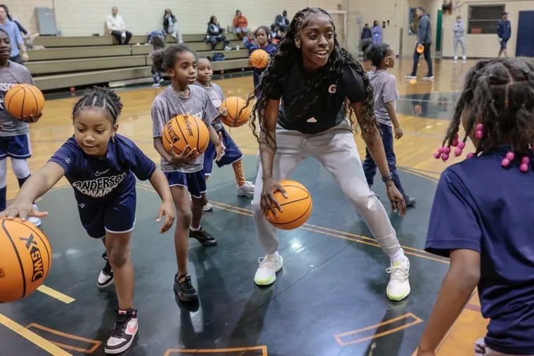 Chicago Sky star Kahleah Copper (center) regularly comes home to North Philly to visit family and friends, and to teach kids about basketball.