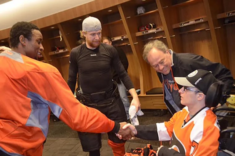 Jackie Lithgow shakes the hand of his favorite player Wayne Simmonds as Jakub Voracek and Jackie's father, Jim, look on. (Courtesy of Zack Hill/Flyers)