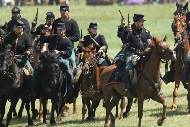 Union cavalry reenactors wheel their horses to the left to cut off the retreat of the Confederate Cavalry during a reenactment of the cavalry battle known as the "Ambush at Hunterstown" during the second day of 150th Gettysburg anniversary reenactment. (Michael Bryant / Staff Photographer)