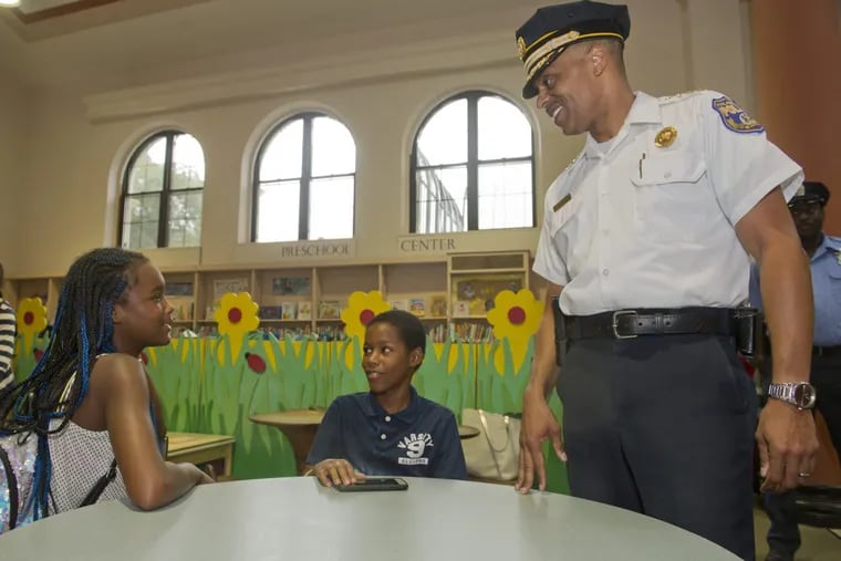 Police Commissioner Richard Ross speaks with twins Christina and Christian Grierson, 10, at the McPherson Square Library.